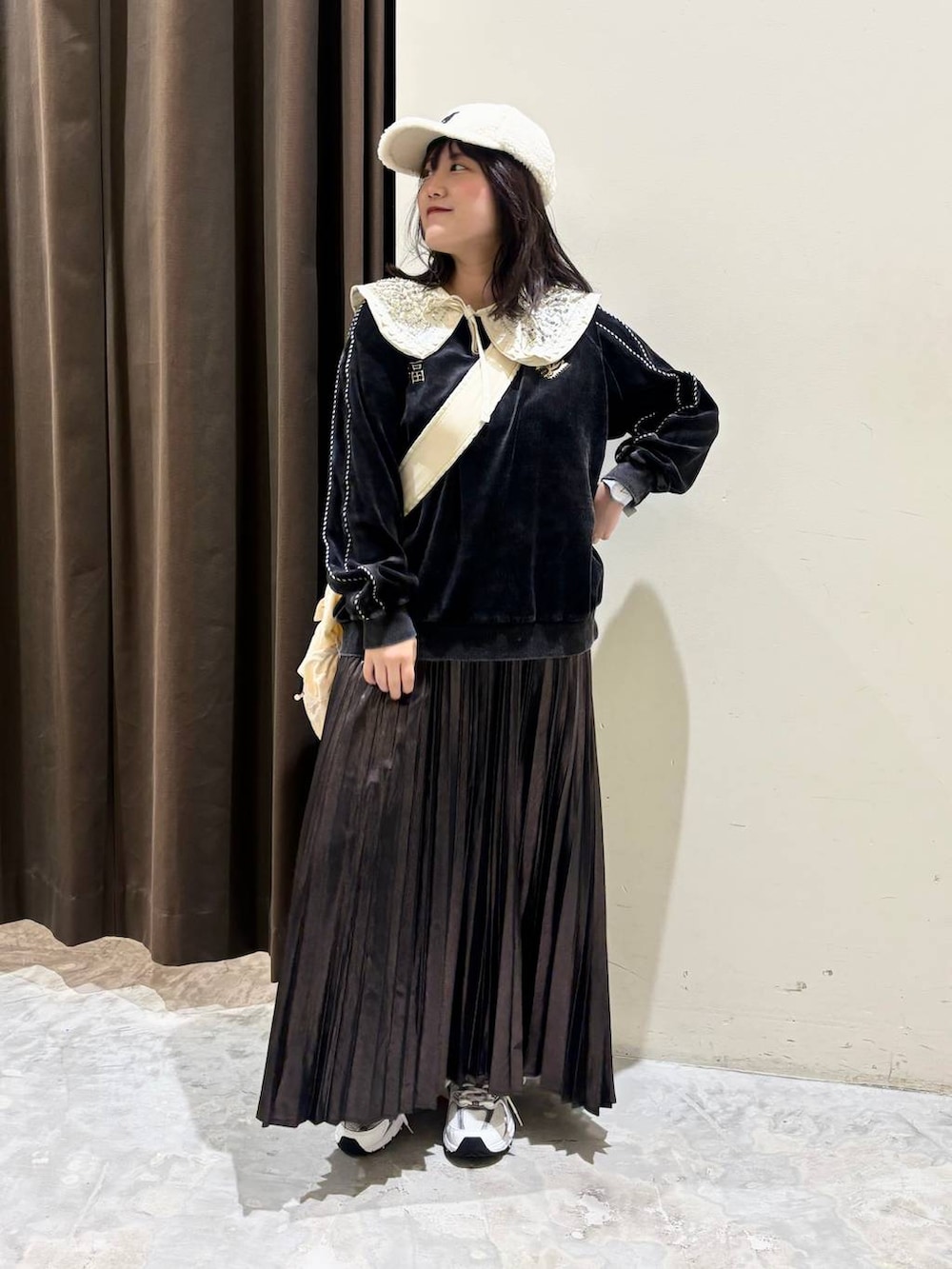 ホワイト系のスニーカー、グレー系のTシャツ/カットソー、ベージュ系のショルダーバッグを着用したレディースの秋コーディネートの3枚目の写真