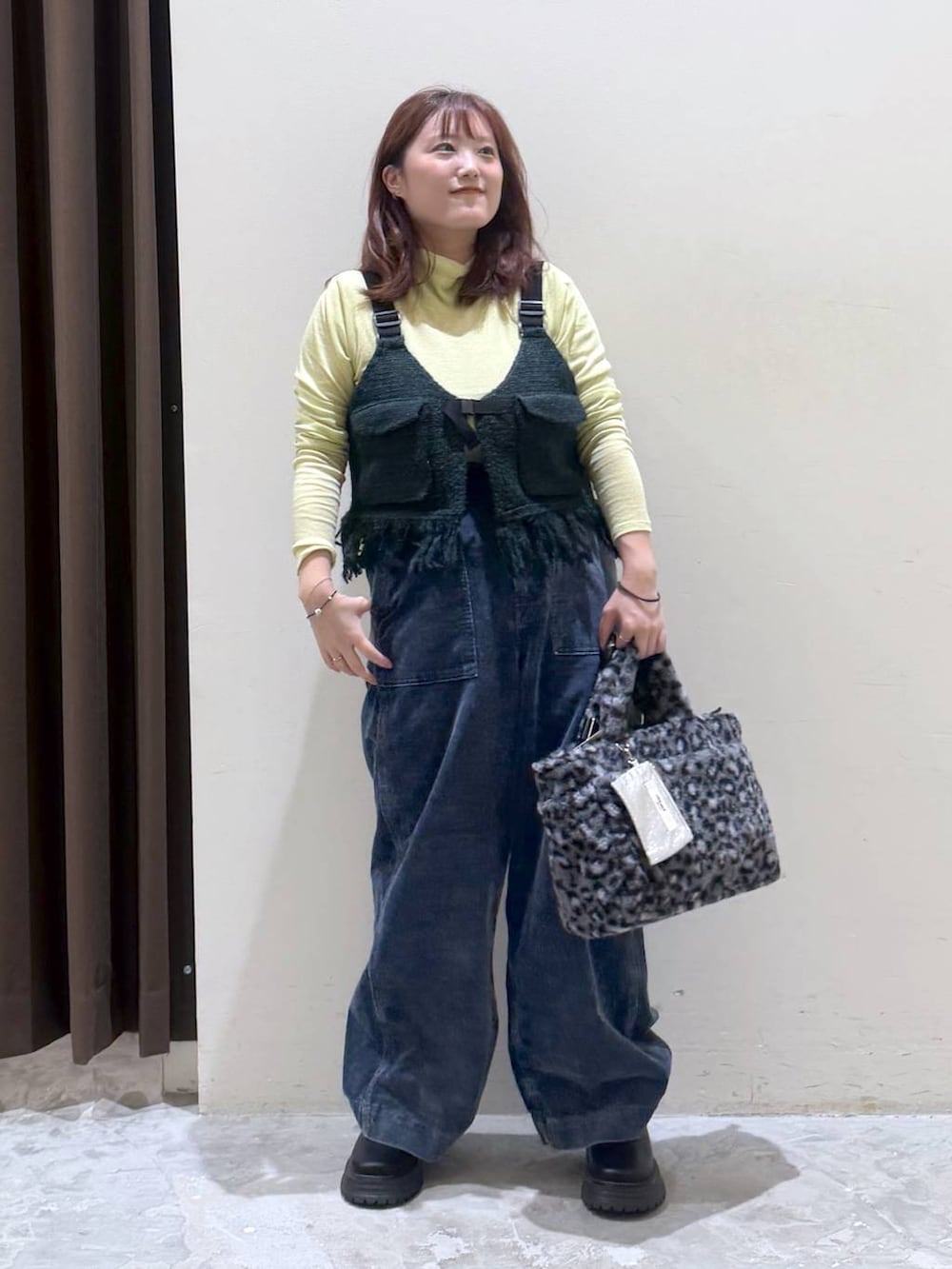 グリーン系のベスト、その他のトートバッグ、イエロー系のTシャツ/カットソーを着用したレディースの秋コーディネートの6枚目の写真