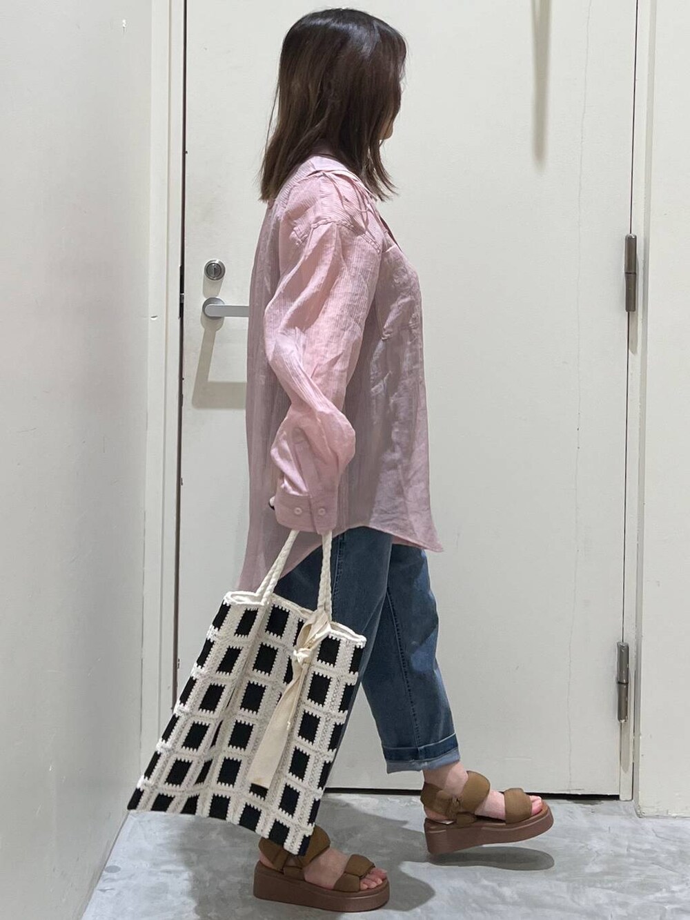 イエロー系のサンダル、ブラック系のトートバッグ、ブルー系のその他パンツを着用したレディースの春コーディネートの5枚目の写真