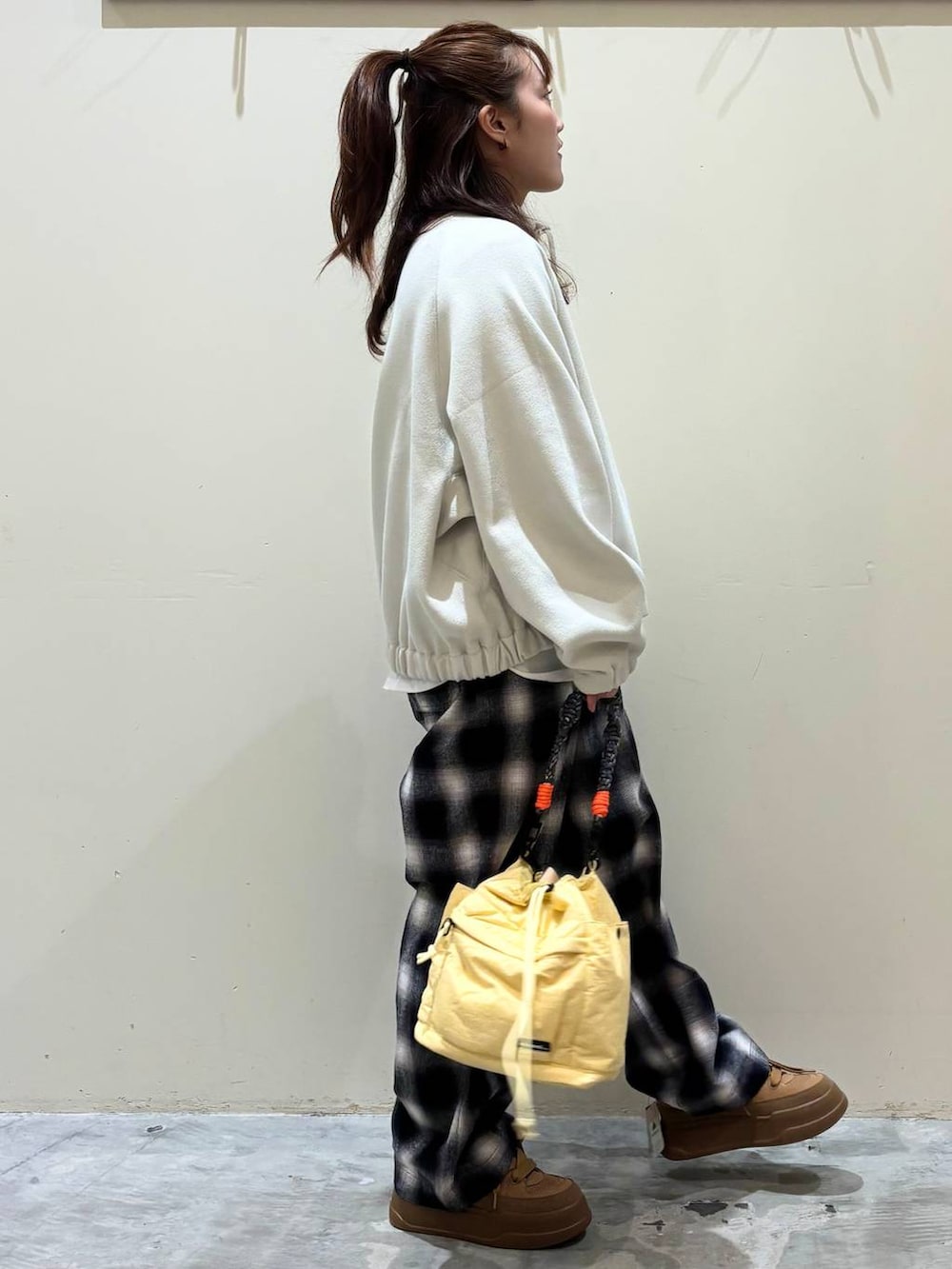 ブラウン系のスニーカー、イエロー系のショルダーバッグを着用したレディースの冬コーディネートの8枚目の写真