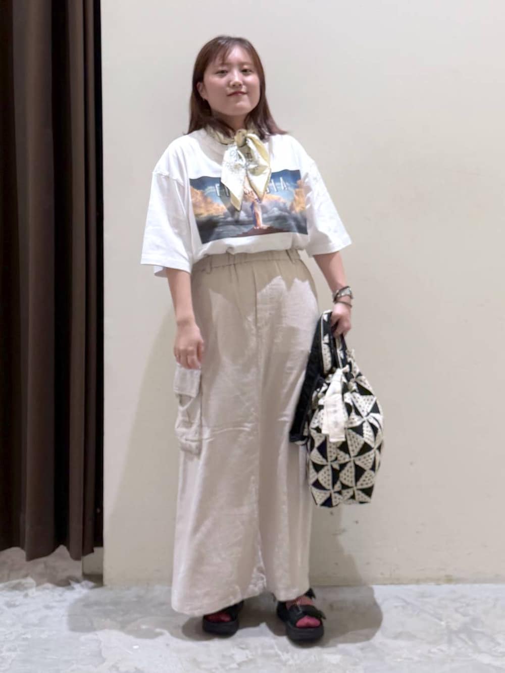 その他のトートバッグ、ベージュ系のスカート、ブラック系のサンダルを着用したレディースの夏コーディネートの3枚目の写真
