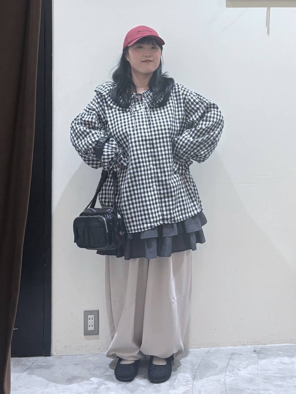 ブラック系のパンプス、ブラック系のショルダーバッグ、ブラック系のシャツ/ブラウスを着用したレディースの春コーディネートの2枚目の写真