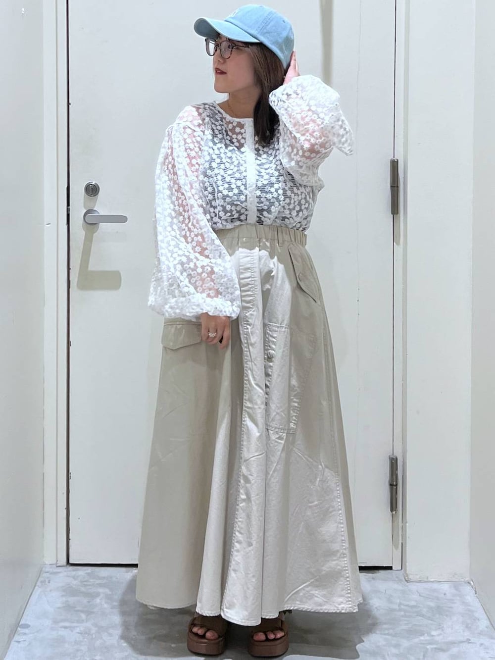 イエロー系のサンダル、ブラウン系のスカート、ホワイト系のTシャツ/カットソーを着用したレディースの春コーディネートの3枚目の写真