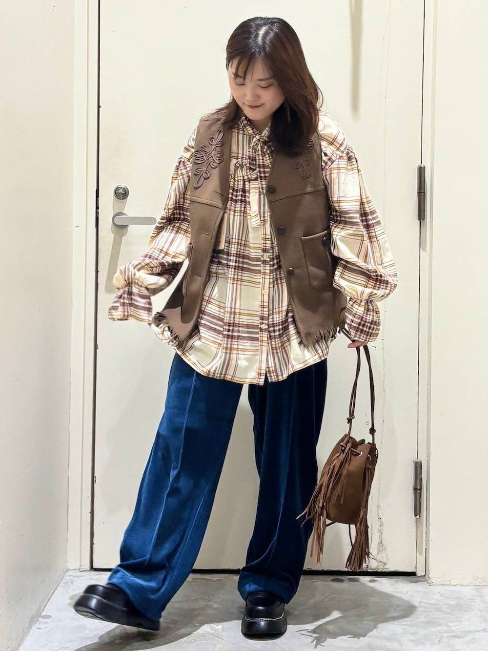 ブルー系のその他パンツ、ベージュ系のシャツ/ブラウス、イエロー系のベストを着用したレディースの秋コーディネートの2枚目の写真