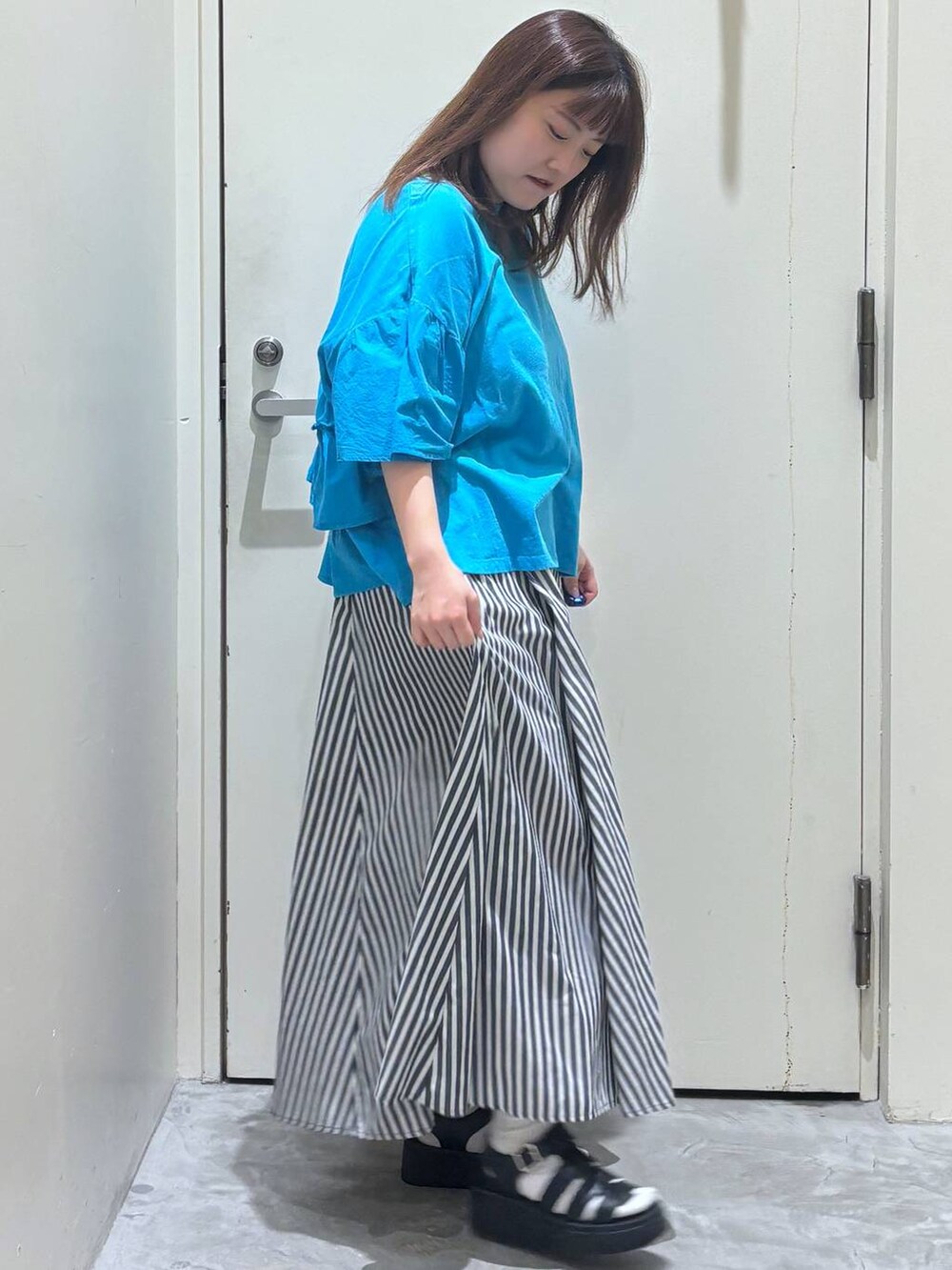 ブラック系のサンダル、ブルー系のスカート、ブルー系のTシャツ/カットソーを着用したレディースの夏コーディネートの4枚目の写真
