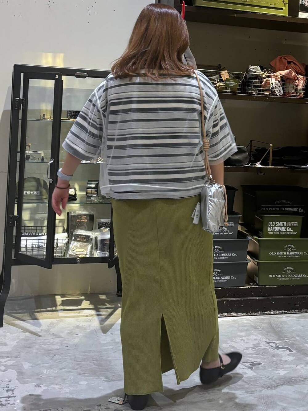 シルバー系のショルダーバッグ、その他のパンプス、グリーン系のスカートを着用したレディースの夏コーディネートの6枚目の写真