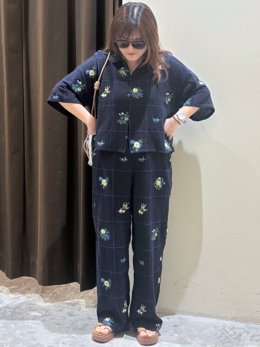 シルバー系のショルダーバッグ、イエロー系のサンダル、ブルー系のその他パンツを着用したレディースの夏コーディネートの2枚目の写真