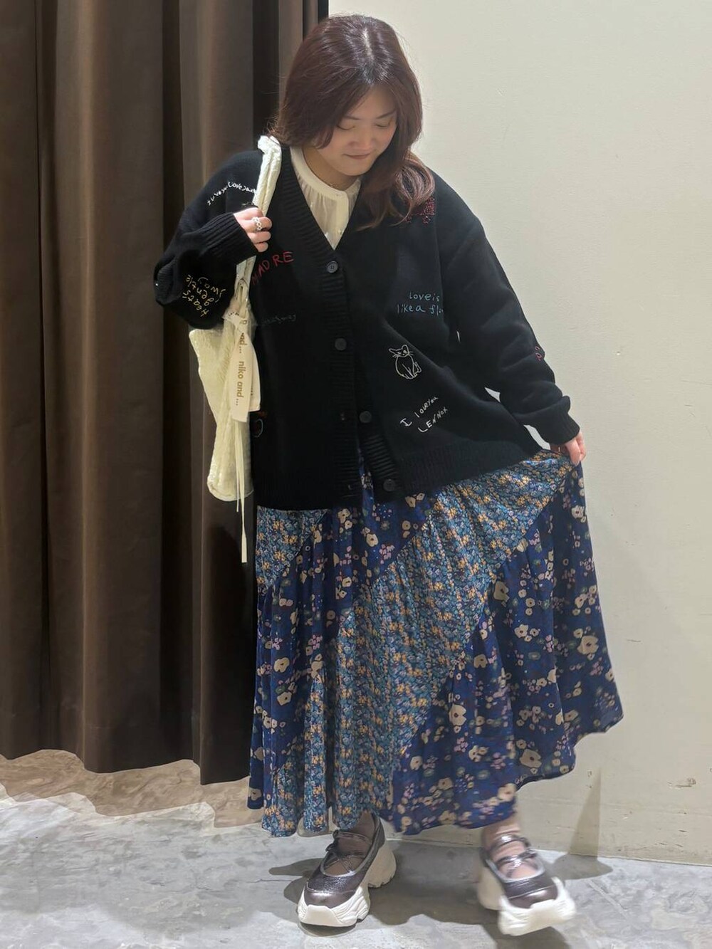 シルバー系のスニーカー、ブルー系のスカート、ホワイト系のシャツ/ブラウスを着用したレディースの秋コーディネートの4枚目の写真