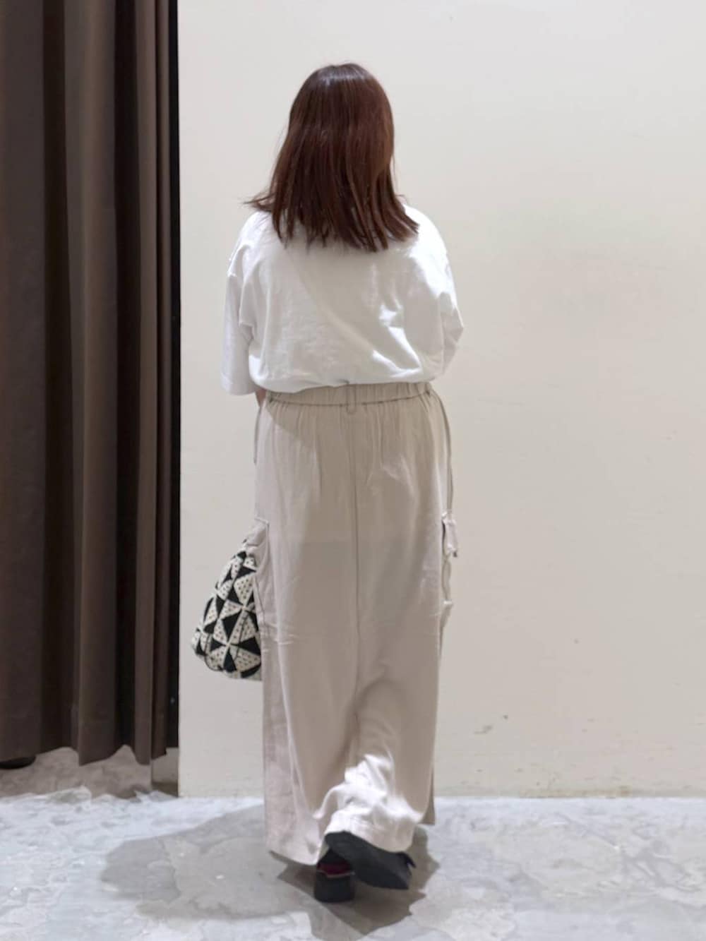 その他のトートバッグ、ベージュ系のスカート、ブラック系のサンダルを着用したレディースの夏コーディネートの5枚目の写真