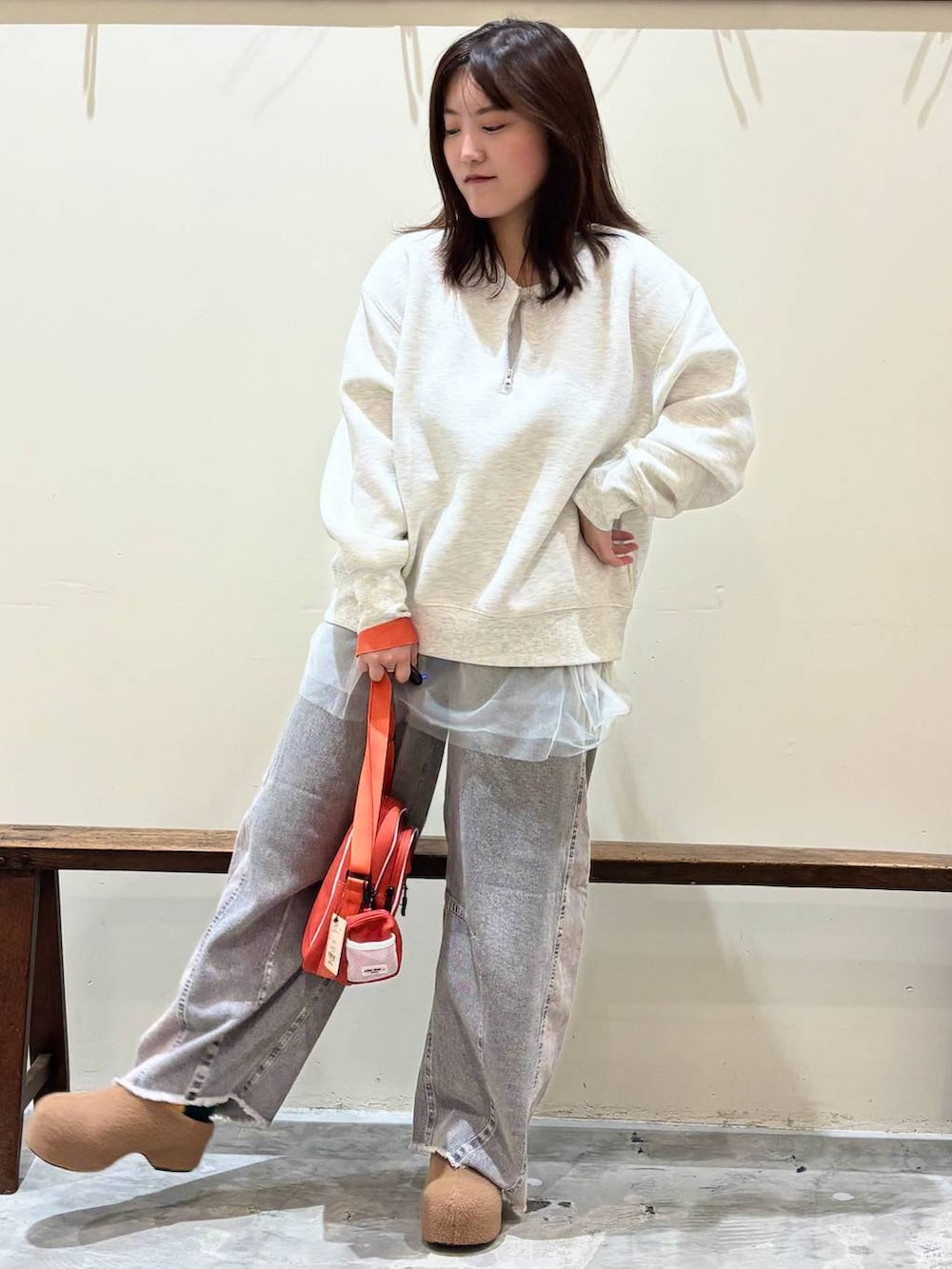 ホワイト系のTシャツ/カットソー、グレー系のデニムパンツ、オレンジ系のショルダーバッグを着用したレディースの秋コーディネートの2枚目の写真