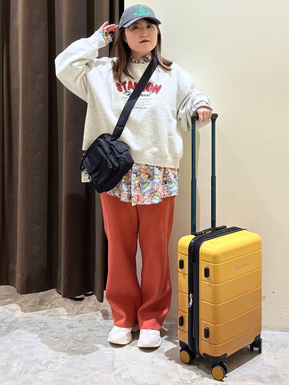 オレンジ系のその他パンツ、ブラック系のショルダーバッグ、ベージュ系のその他トップスを着用したレディースの冬コーディネートの4枚目の写真