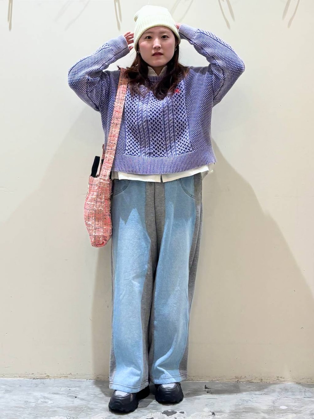 グレー系のデニムパンツ、グレー系のスニーカー、ピンク系のトートバッグを着用したレディースの冬コーディネートの4枚目の写真