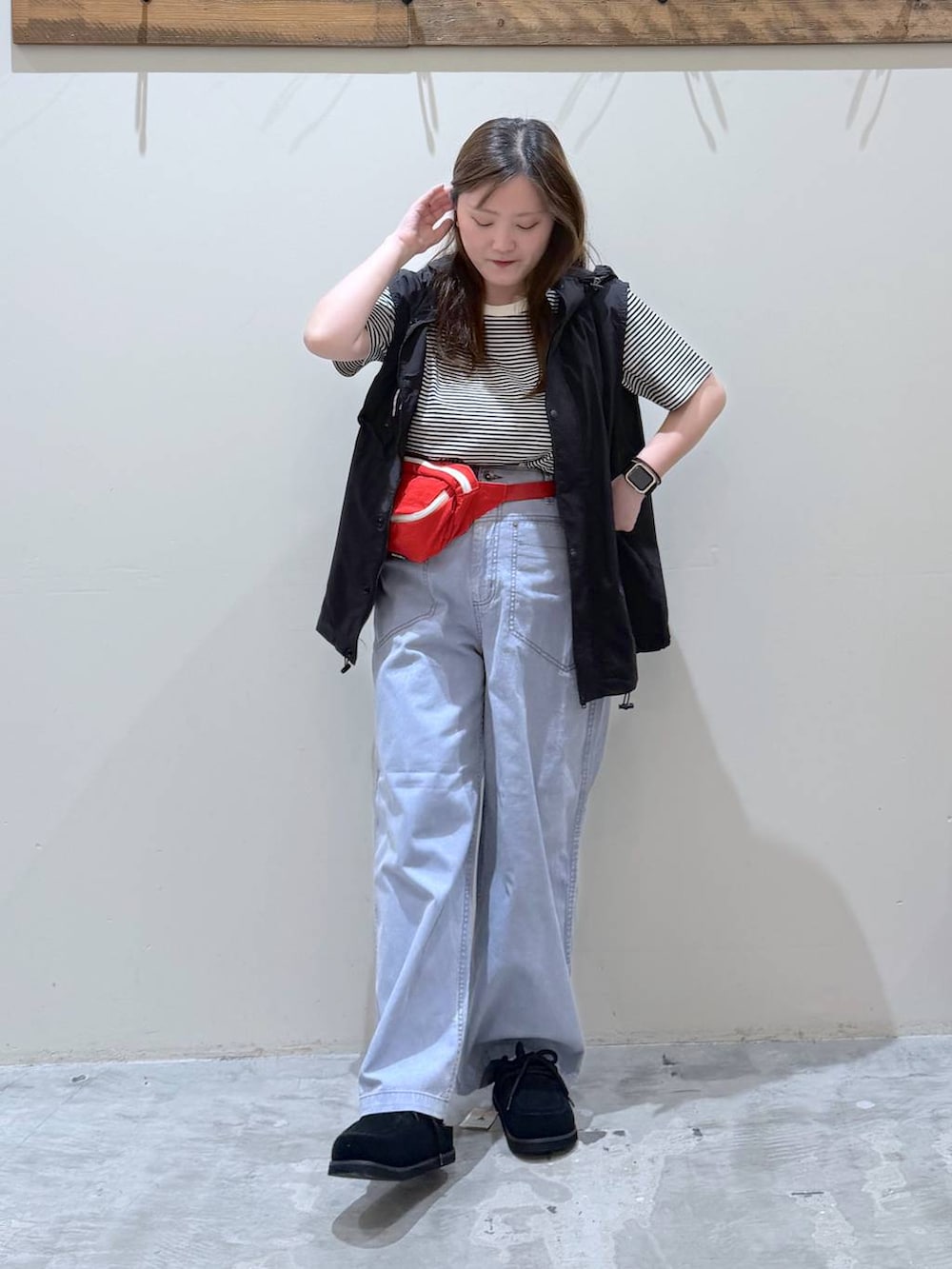 ブルー系のその他パンツ、ブラック系のスニーカー、ブラック系のベストを着用したレディースの春コーディネートの2枚目の写真