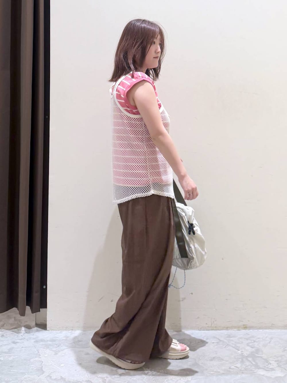 ベージュ系のサンダル、ベージュ系のボストンバッグ、ピンク系のTシャツ/カットソーを着用したレディースの夏コーディネートの3枚目の写真