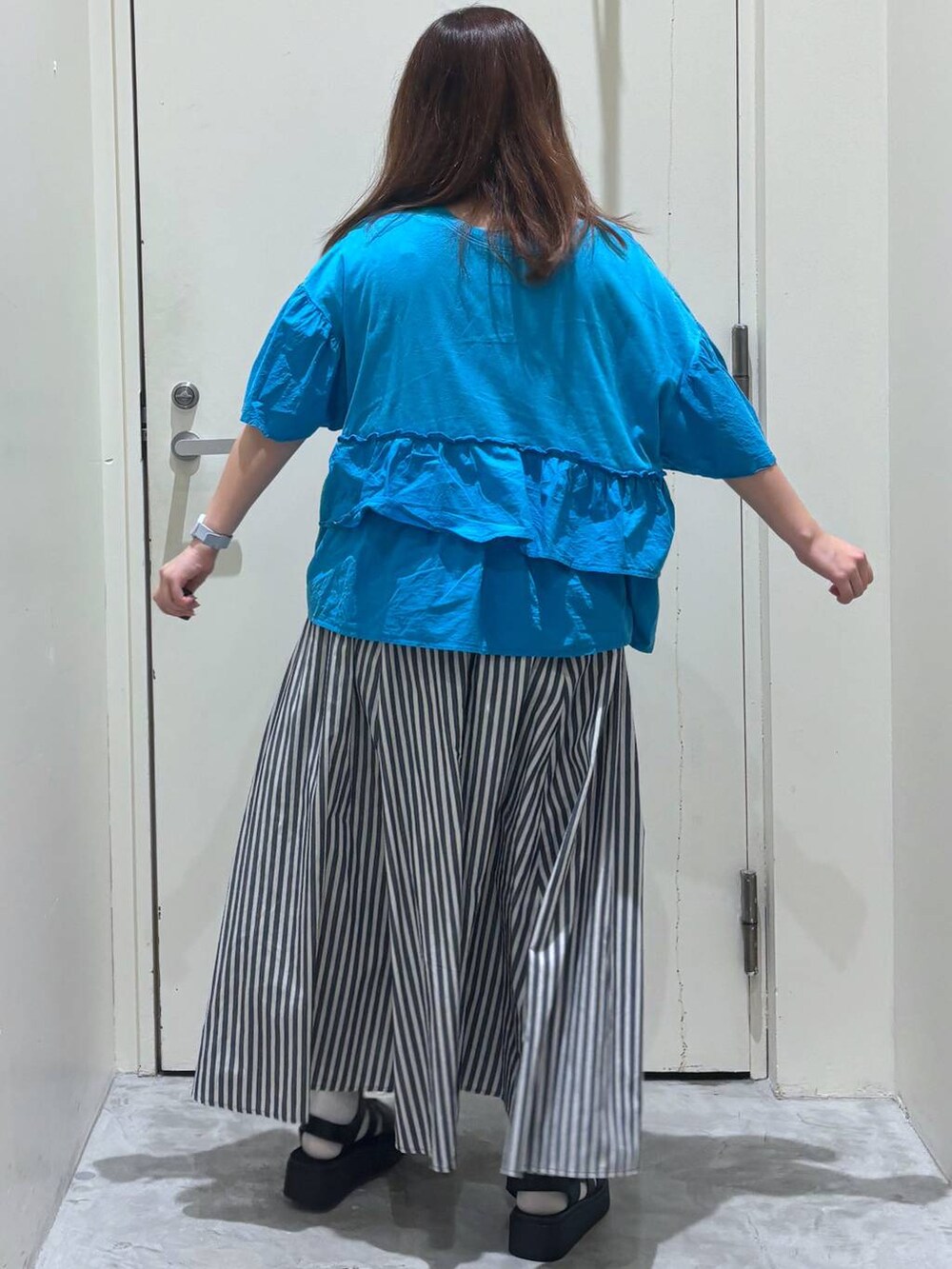 ブラック系のサンダル、ブルー系のスカート、ブルー系のTシャツ/カットソーを着用したレディースの夏コーディネートの5枚目の写真