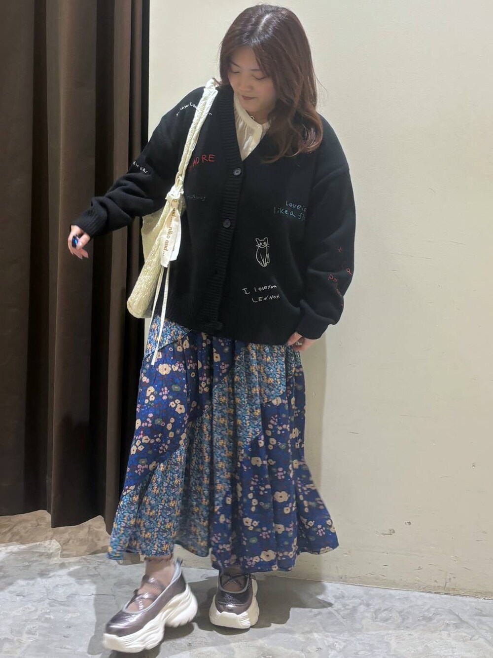 シルバー系のスニーカー、ブルー系のスカート、ホワイト系のシャツ/ブラウスを着用したレディースの秋コーディネートの3枚目の写真