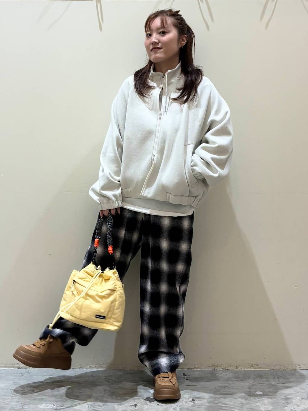 ブラウン系のスニーカー、イエロー系のショルダーバッグを着用したレディースの冬コーディネートの7枚目の写真