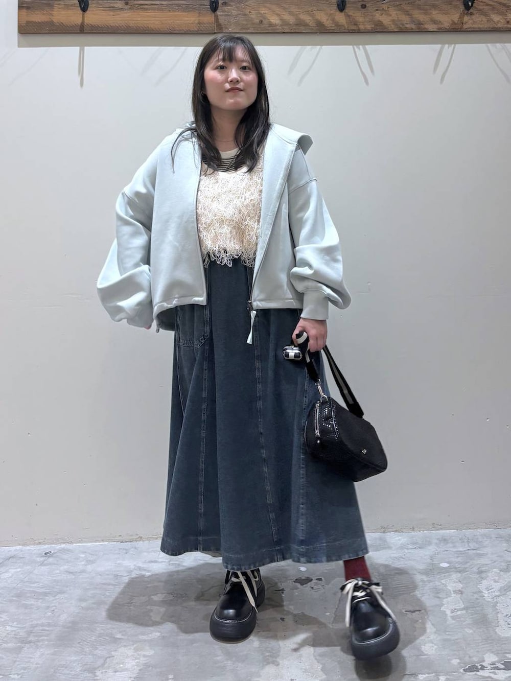 ブルー系のスカート、ブラック系のその他シューズ、ベージュ系のTシャツ/カットソーを着用したレディースの春コーディネートの2枚目の写真