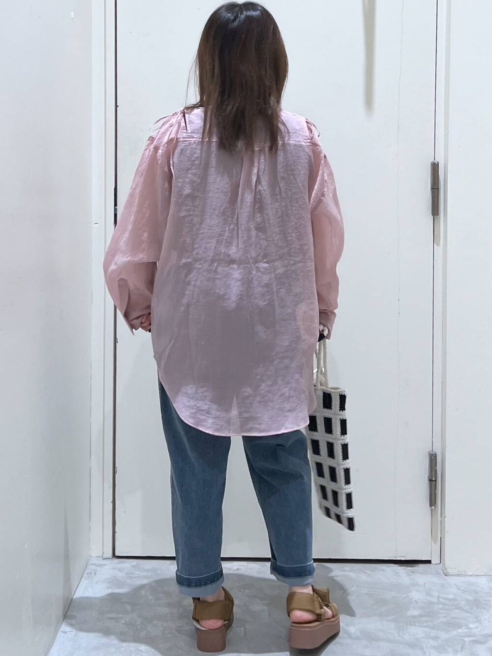 イエロー系のサンダル、ブラック系のトートバッグ、ブルー系のその他パンツを着用したレディースの春コーディネートの6枚目の写真