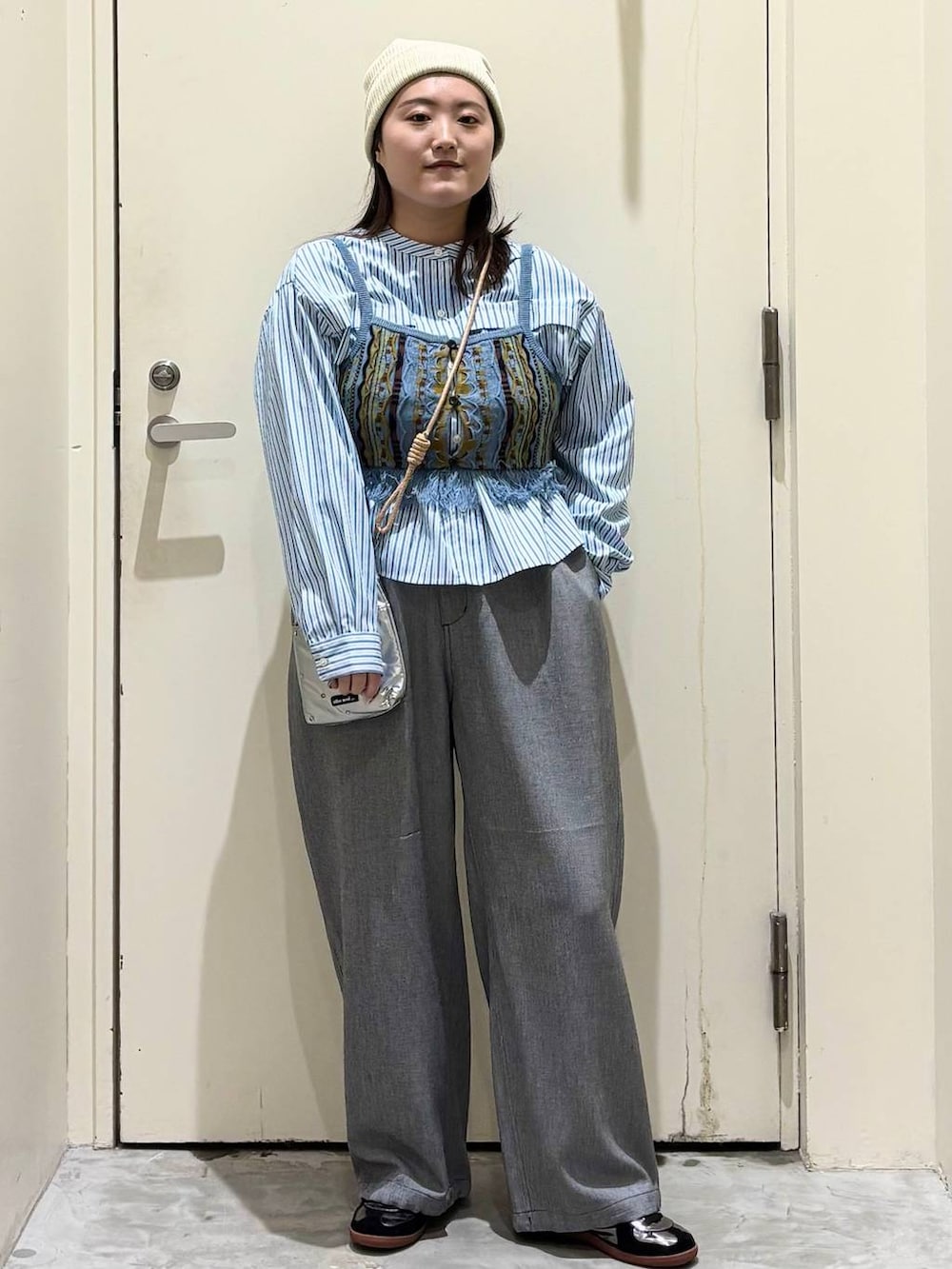 シルバー系のショルダーバッグ、グレー系のその他パンツ、シルバー系のスニーカーを着用したレディースの春コーディネートの4枚目の写真