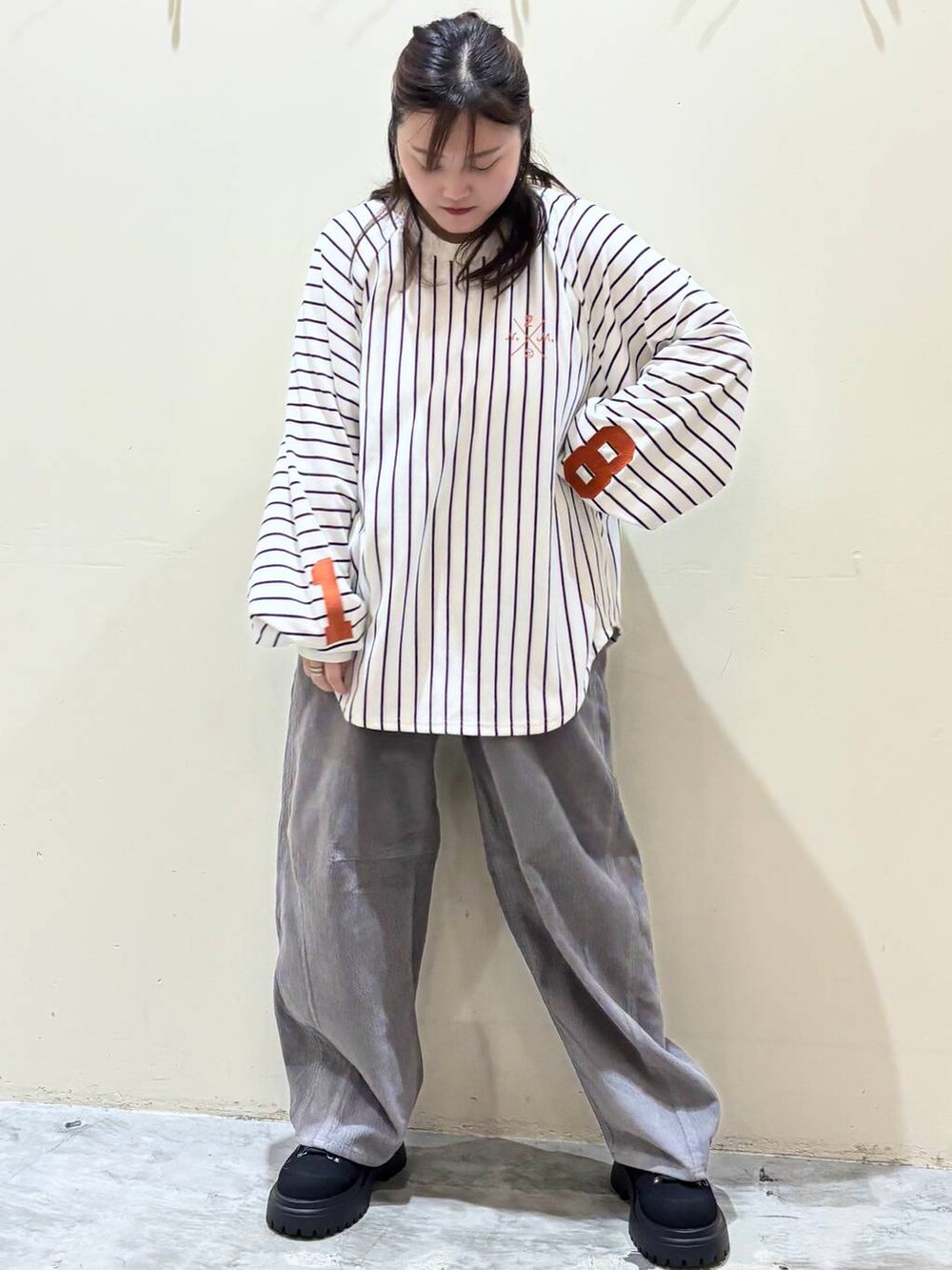 グレー系のその他パンツ、オレンジ系のトートバッグ、ブラック系のその他シューズを着用したレディースの秋コーディネートの6枚目の写真