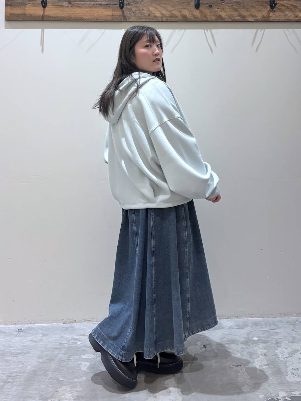 ブルー系のスカート、ブラック系のその他シューズ、ベージュ系のTシャツ/カットソーを着用したレディースの春コーディネートの3枚目の写真