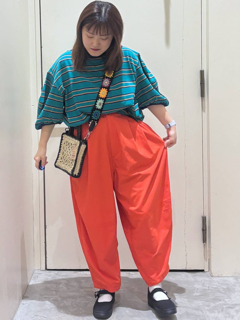 ブラック系のショルダーバッグ、オレンジ系のその他パンツ、グリーン系のTシャツ/カットソーを着用したレディースの夏コーディネートの5枚目の写真