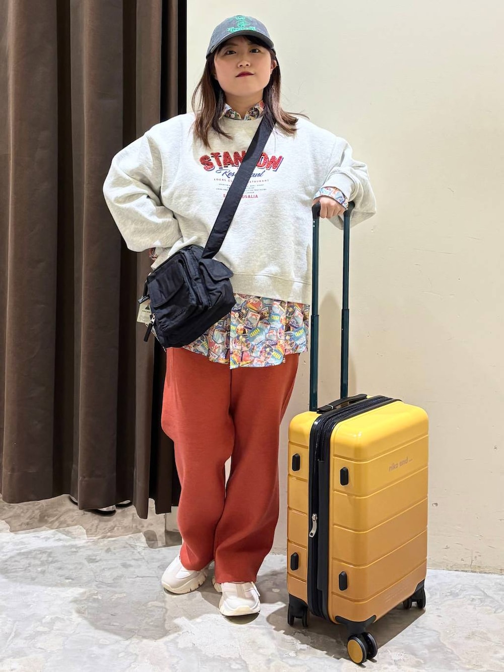 オレンジ系のその他パンツ、ブラック系のショルダーバッグ、ベージュ系のその他トップスを着用したレディースの冬コーディネートの2枚目の写真