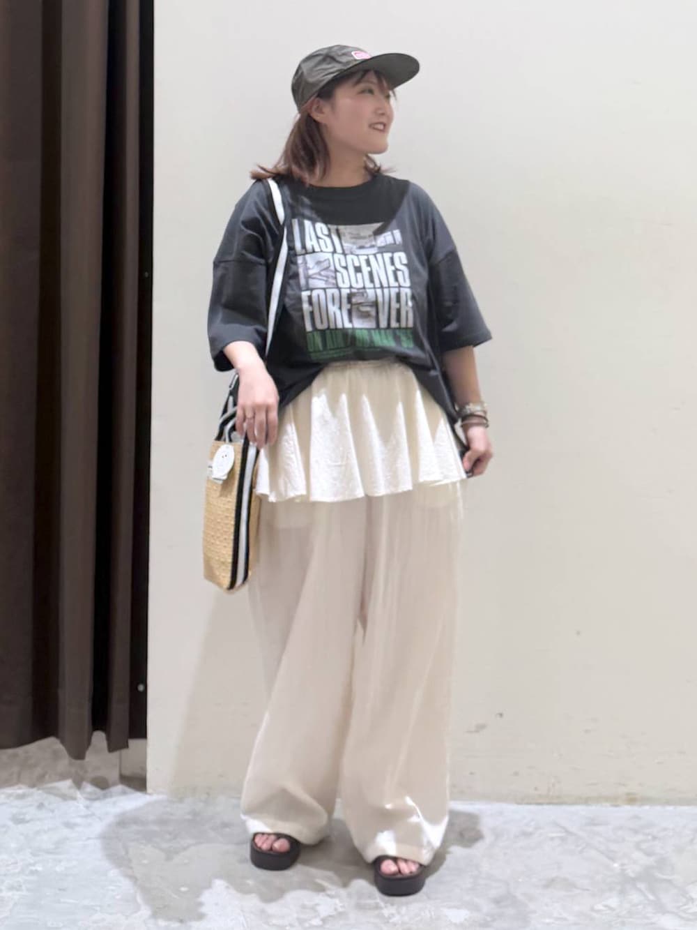 ブラウン系のサンダル、ベージュ系のトートバッグ、グレー系のTシャツ/カットソーを着用したレディースの夏コーディネートの2枚目の写真