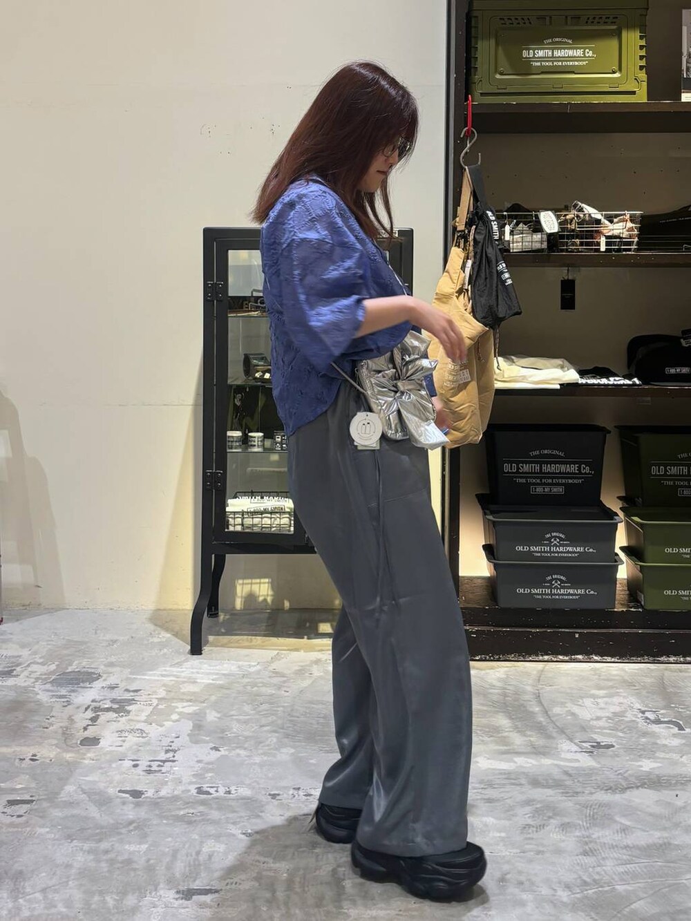 ブラック系のスニーカー、グレー系のショルダーバッグ、ブルー系のシャツ/ブラウスを着用したレディースの夏コーディネートの6枚目の写真