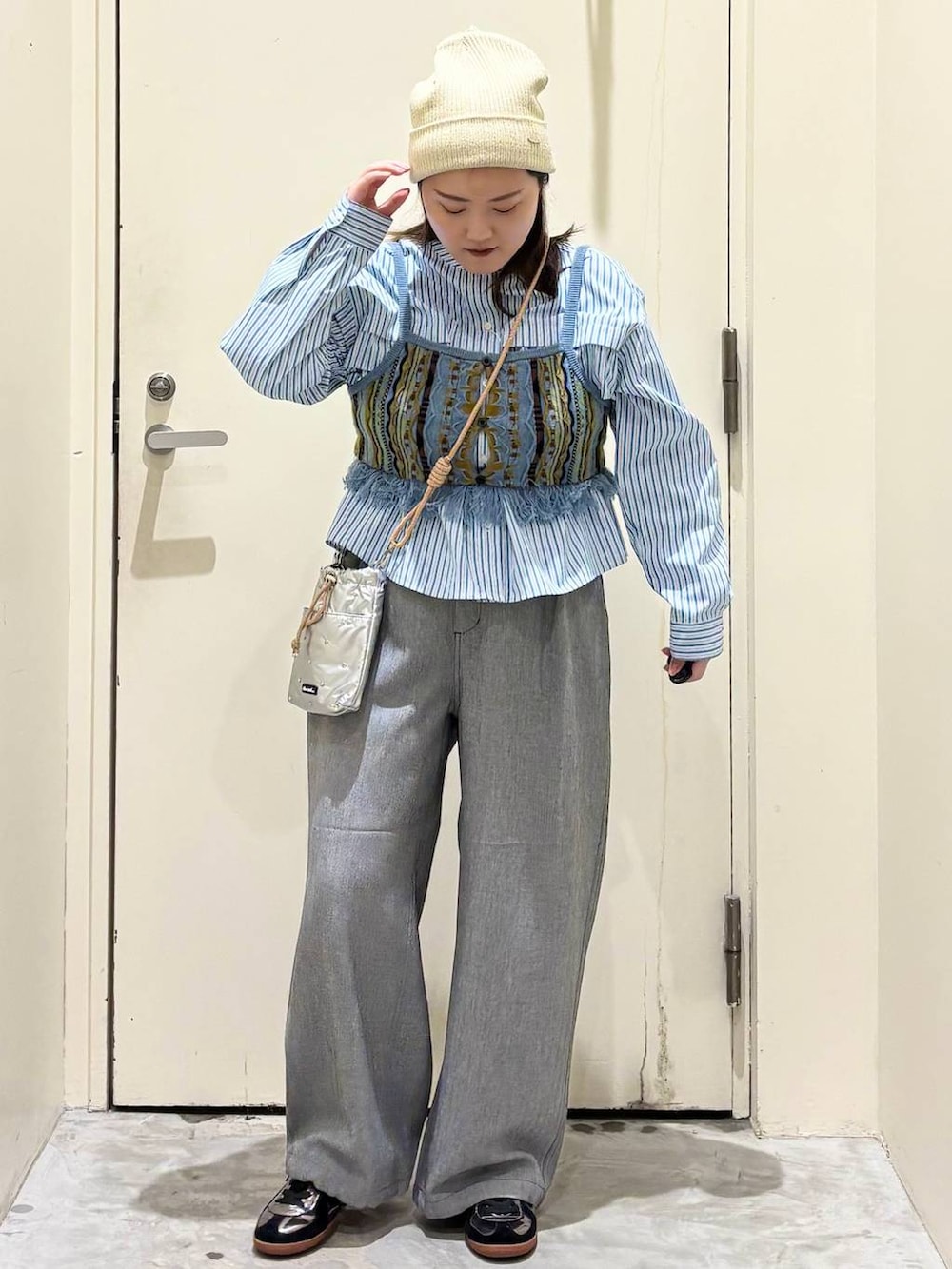 シルバー系のショルダーバッグ、グレー系のその他パンツ、シルバー系のスニーカーを着用したレディースの春コーディネートの2枚目の写真