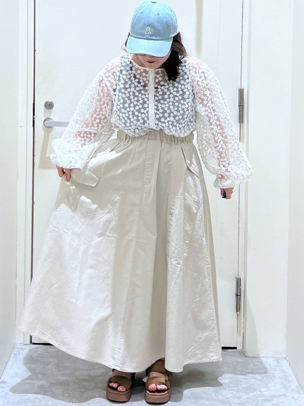 イエロー系のサンダル、ブラウン系のスカート、ホワイト系のTシャツ/カットソーを着用したレディースの春コーディネートの2枚目の写真