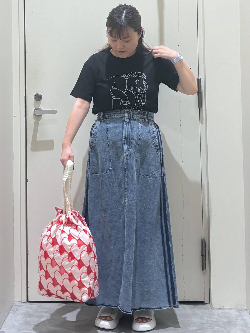 ベージュ系のサンダル、その他のトートバッグ、ブラック系のTシャツ/カットソーを着用したレディースの夏コーディネートの2枚目の写真
