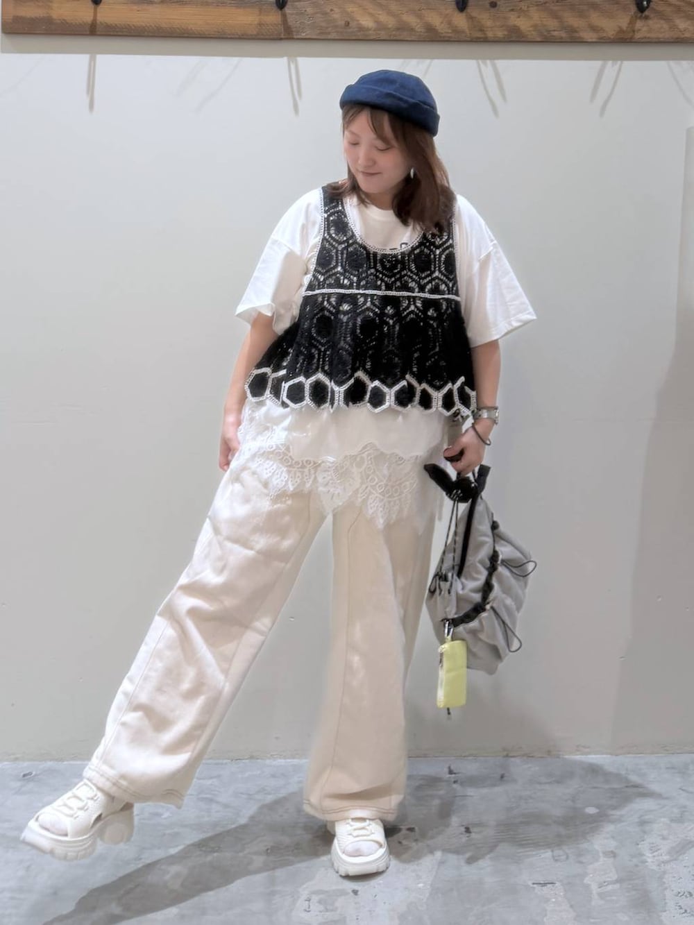 ベージュ系のデニムパンツ、ブラック系のその他トップス、ベージュ系のサンダルを着用したレディースの夏コーディネートの4枚目の写真