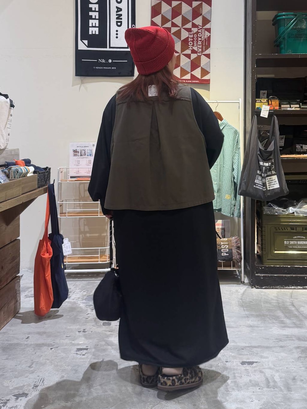 ブラック系のショルダーバッグ、その他のモカシン/デッキシューズ、レッド系のニットキャップ/ビーニーを着用したレディースの秋コーディネートの4枚目の写真