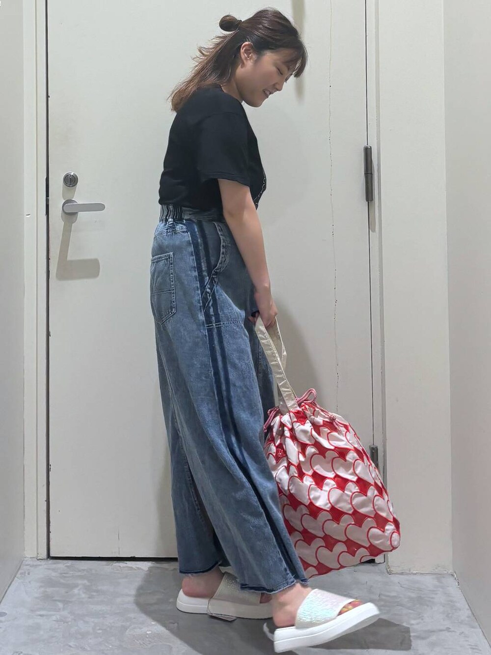 ベージュ系のサンダル、その他のトートバッグ、ブラック系のTシャツ/カットソーを着用したレディースの夏コーディネートの6枚目の写真