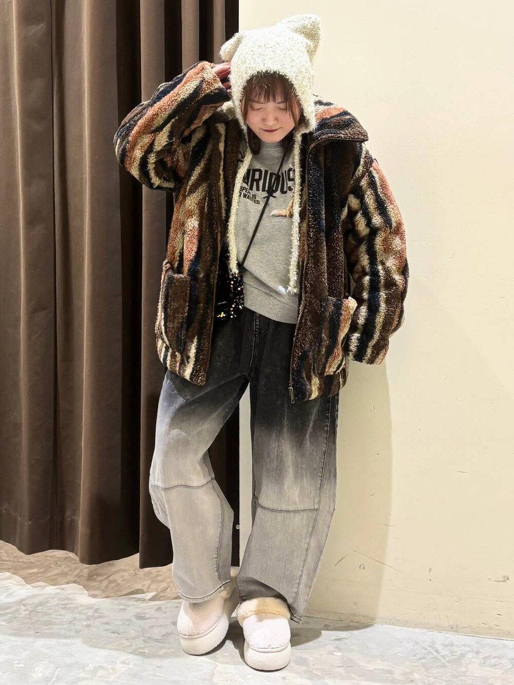 ブラウン系のブルゾン、ブラック系のデニムパンツ、グレー系のスウェットを着用したレディースの秋コーディネートの3枚目の写真
