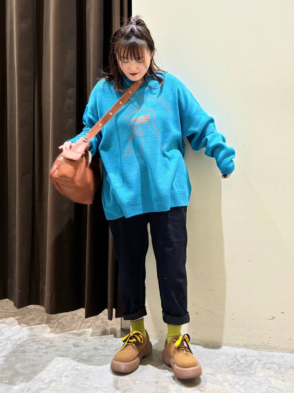 ブルー系のニット/セーター、ブラウン系のショルダーバッグ、イエロー系のその他シューズを着用したレディースの冬コーディネートの2枚目の写真