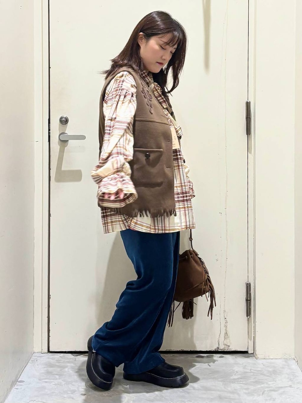 ブルー系のその他パンツ、ベージュ系のシャツ/ブラウス、イエロー系のベストを着用したレディースの秋コーディネートの4枚目の写真