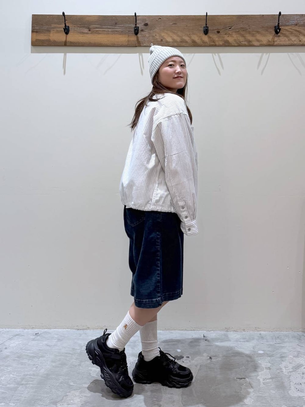 ブラック系のスニーカー、ベージュ系のカバーオール、レッド系のTシャツ/カットソーを着用したレディースの春コーディネートの3枚目の写真