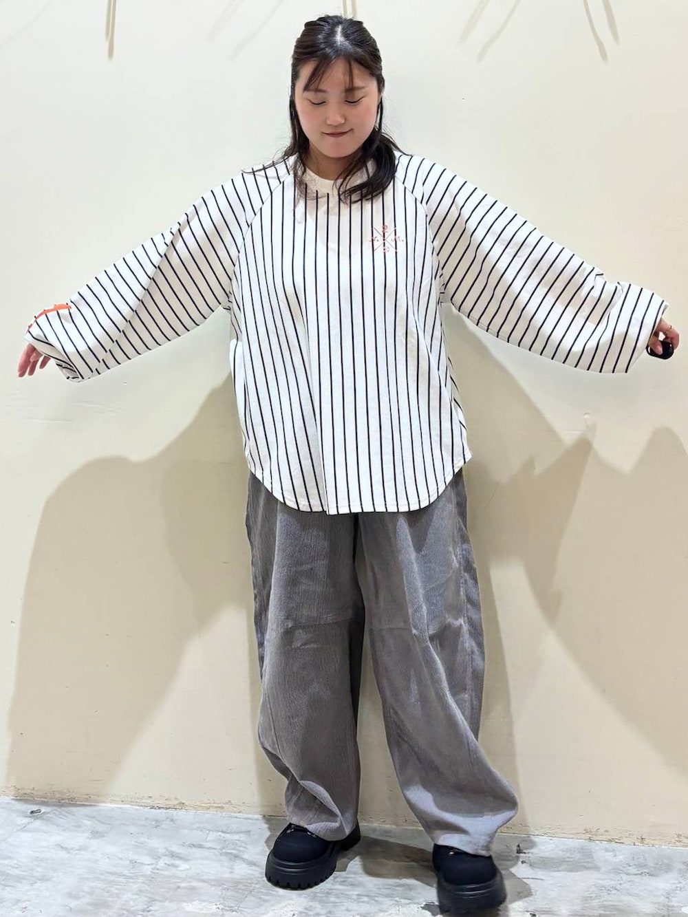 グレー系のその他パンツ、オレンジ系のトートバッグ、ブラック系のその他シューズを着用したレディースの秋コーディネートの5枚目の写真