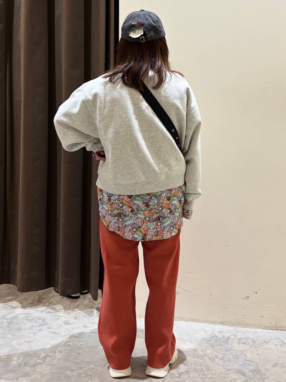 オレンジ系のその他パンツ、ブラック系のショルダーバッグ、ベージュ系のその他トップスを着用したレディースの冬コーディネートの6枚目の写真