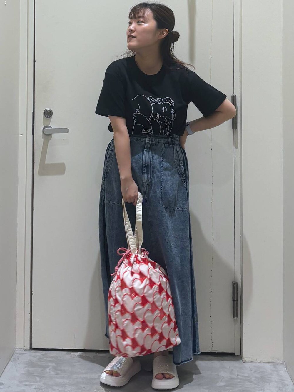 ベージュ系のサンダル、その他のトートバッグ、ブラック系のTシャツ/カットソーを着用したレディースの夏コーディネートの3枚目の写真