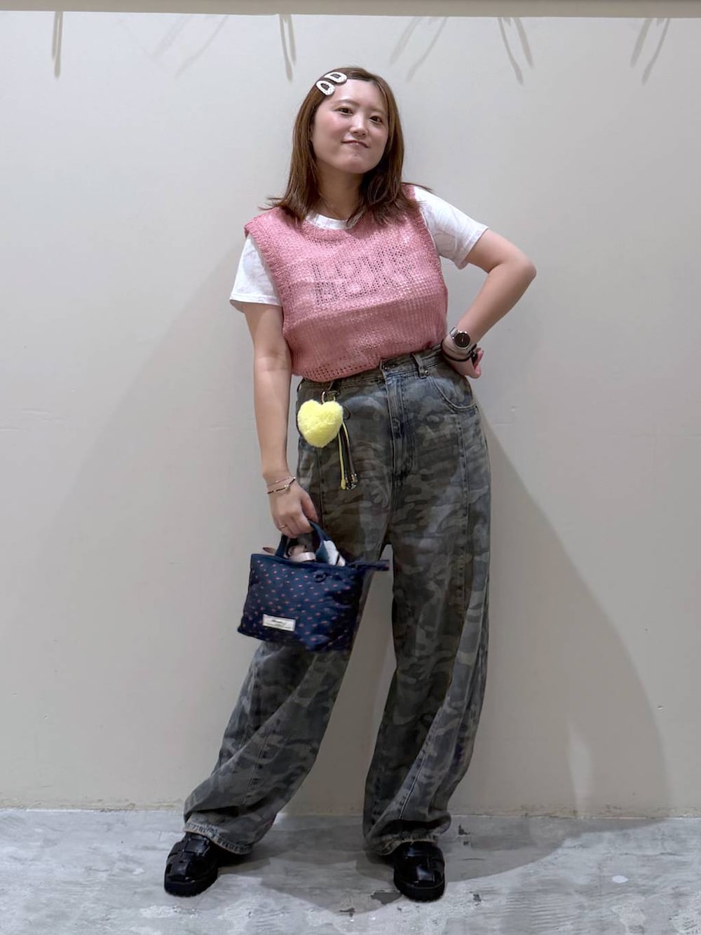 ピンク系のベスト、その他のトートバッグ、グリーン系のデニムパンツを着用したレディースの夏コーディネートの4枚目の写真