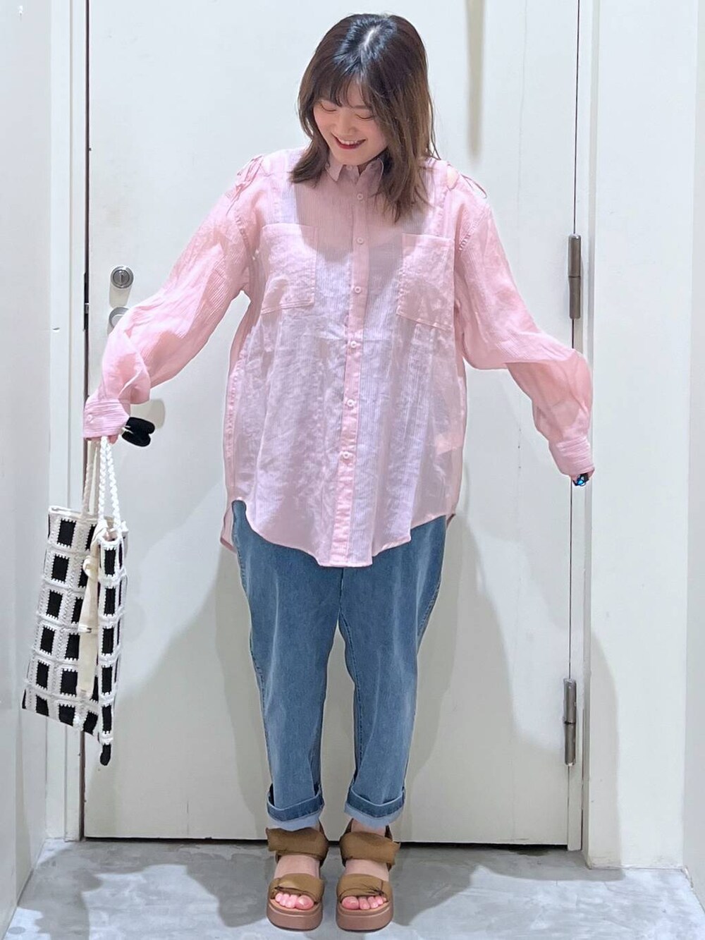 イエロー系のサンダル、ブラック系のトートバッグ、ブルー系のその他パンツを着用したレディースの春コーディネートの3枚目の写真