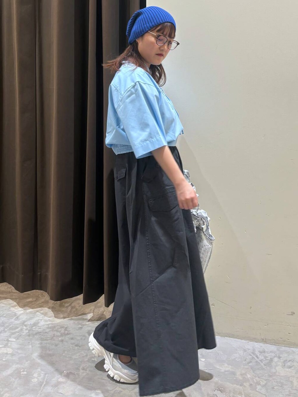 シルバー系のトートバッグ、シルバー系のスニーカー、グレー系のスカートを着用したレディースの夏コーディネートの5枚目の写真