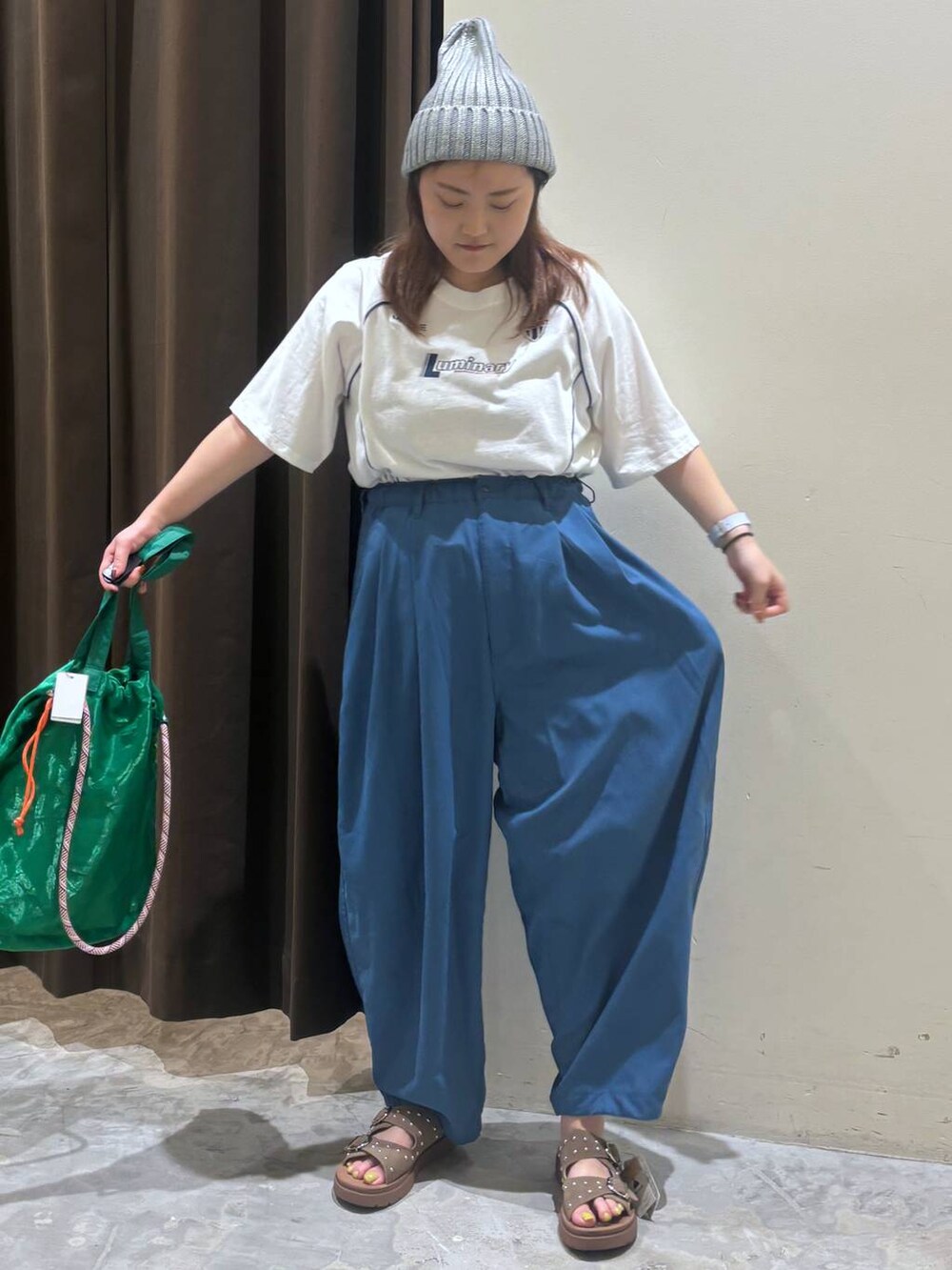 ベージュ系のサンダル、ブルー系のその他パンツ、グリーン系のトートバッグを着用したレディースの夏コーディネートの3枚目の写真