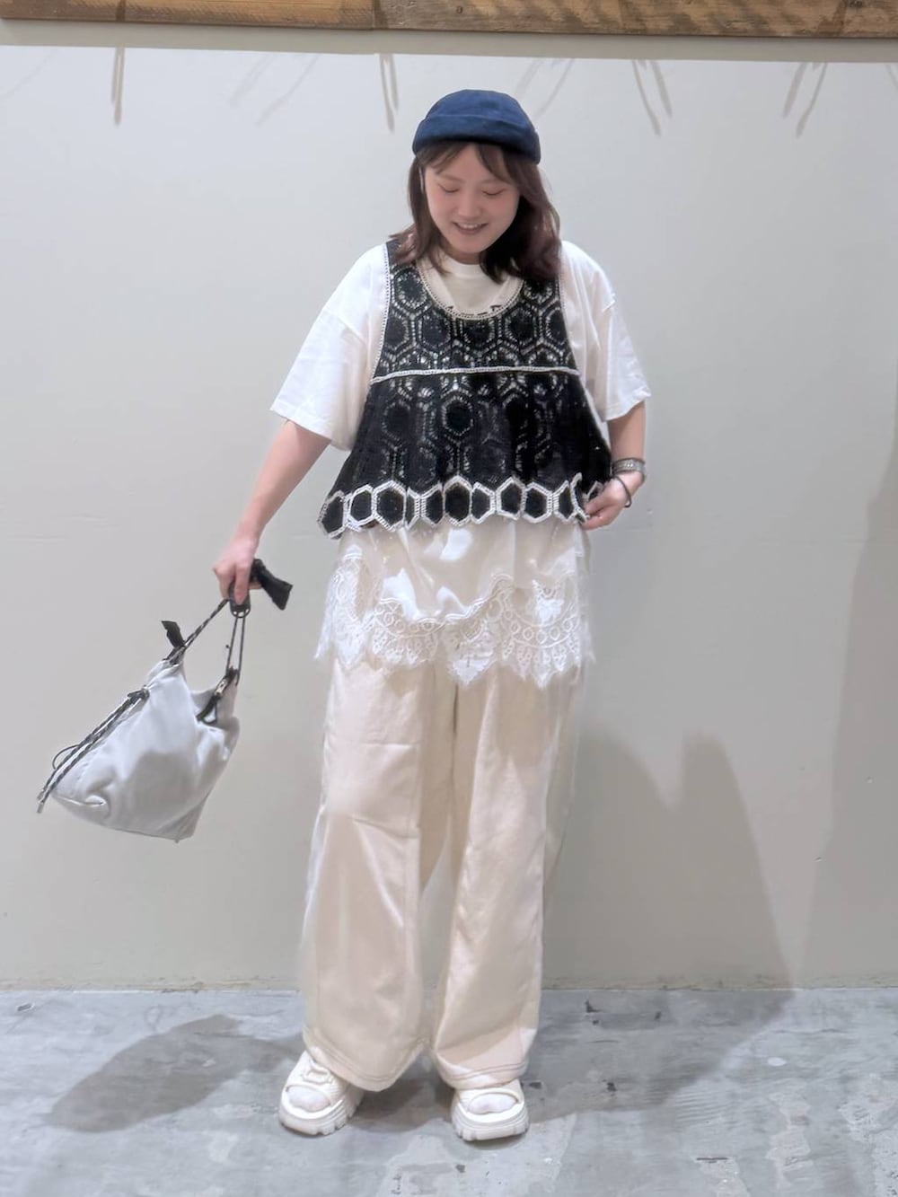 ベージュ系のデニムパンツ、ブラック系のその他トップス、ベージュ系のサンダルを着用したレディースの夏コーディネートの3枚目の写真
