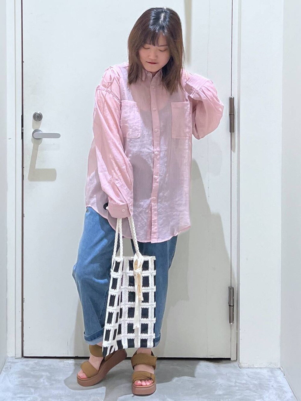 イエロー系のサンダル、ブラック系のトートバッグ、ブルー系のその他パンツを着用したレディースの春コーディネートの2枚目の写真