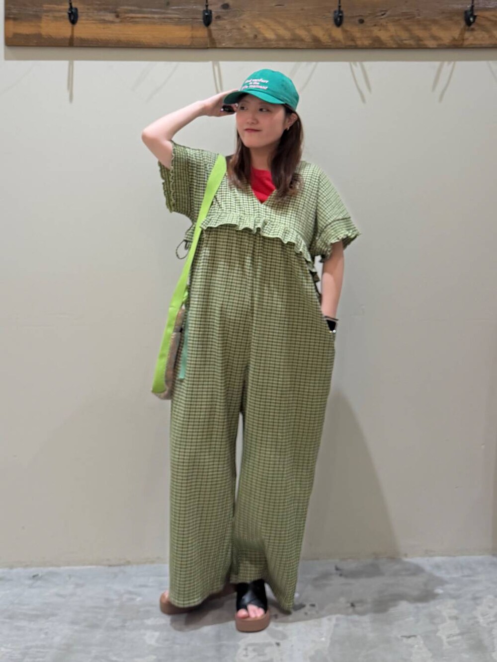 ブラック系のサンダル、レッド系のTシャツ/カットソー、イエロー系のつなぎ/オールインワンを着用したレディースの春コーディネートの5枚目の写真